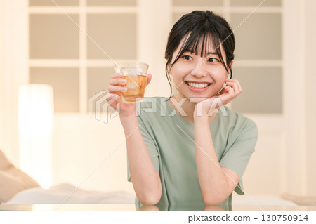 一位年輕的亞洲女性在家中臥室喝酒（在家喝酒、微醺、在家喝酒、喝酒） 130750914