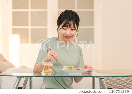 一位獨居的年輕亞洲女性正在吃晚餐 130751289