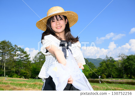 A girl enjoying catching insects under the blue sky 130752256