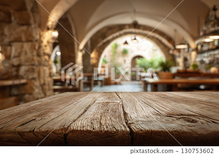 Rustic Mediterranean stone interior with wooden table and warm vintage lighting 130753602