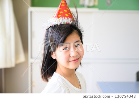 教室裡戴著活動帽的小學女孩 教室裡戴著活動帽的小學女孩 130754348