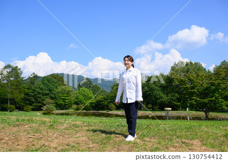 A housewife relaxing on a plateau under the blue sky. Nature, Holidays, Lifestyle A housewife relaxing on a plateau under the blue sky. Nature, Holidays, Lifestyle 130754412
