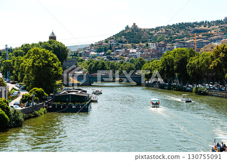 River flows through Tbilisi with boats and greenery during sunny afternoon in Georgia River flows through Tbilisi with boats and greenery during sunny afternoon in Georgia 130755091