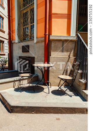 Cozy outdoor seating arrangement at a charming building in the city on a sunny day 130755192