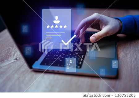 User engaging with digital platform to leave feedback and rate experience on a laptop during evening hours 130755203