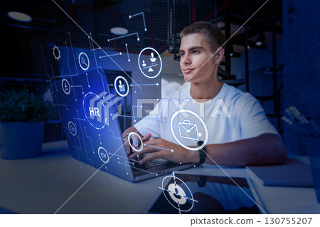 Young professional working on human resources tasks with digital interface in modern office setting 130755207