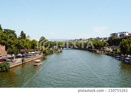 Serenity of the river gracefully flowing through a lively urban landscape in summer 130755261