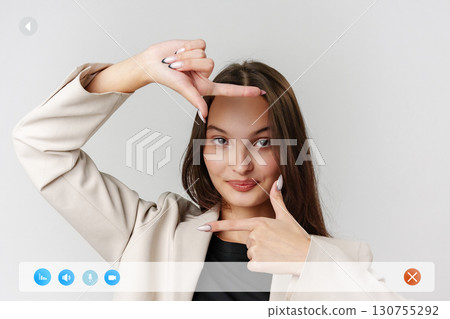 Creative poses by a young woman in a light-colored blazer against a plain backdrop showcasing expressive hand gestures 130755292