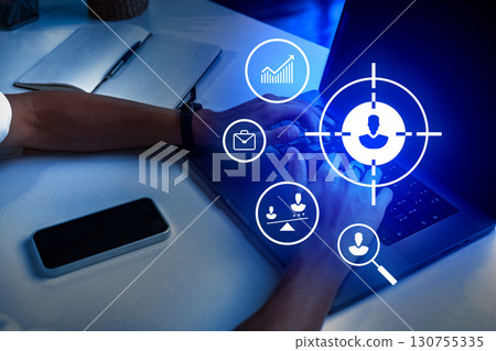Hands typing on a laptop with digital icons symbolizing data analytics and communication displayed on the screen at night 130755335