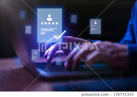 User engaging with digital documents on a laptop with glowing icons in a modern workspace environment 130755355
