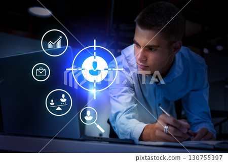 Young professional analyzes data on laptop while focusing on task in modern workspace Young professional analyzes data on laptop while focusing on task in modern workspace 130755397