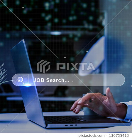 Person using laptop for job search in modern workspace during evening hours with digital interface elements 130755413
