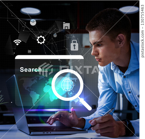 Young man engaged in online research with a laptop in a modern office environment 130755463