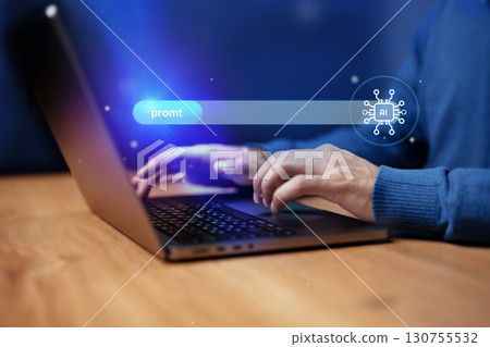 User interacting with AI interface on laptop during evening work session 130755532