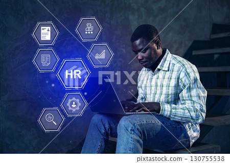 Working on human resources tasks with digital tools in a modern workspace during evening hours Working on human resources tasks with digital tools in a modern workspace during evening hours 130755538