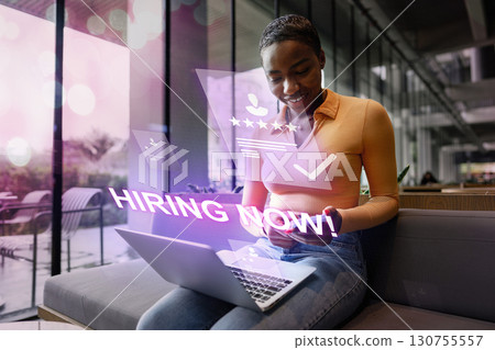 Job seeker engaging with online hiring platform while working on laptop in modern cafe setting during the day 130755557