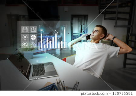 Young professional enjoying successful business performance while working late in modern office 130755591