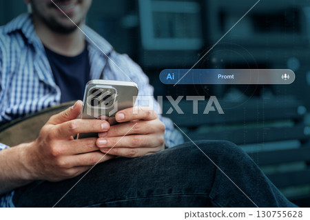 Man using smartphone to engage in digital interaction at a public space during afternoon hours Man using smartphone to engage in digital interaction at a public space during afternoon hours 130755628
