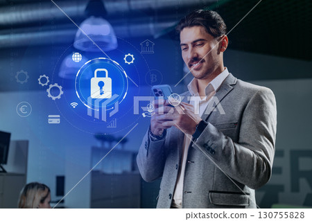 Professional man using smartphone with digital security icons in modern office environment Professional man using smartphone with digital security icons in modern office environment 130755828