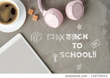 Back to school essentials with pink headphones, coffee, and notepad on a clean surface 130756010