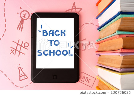 Back to school preparations with a tablet and stacked books on a pink background filled with fun learning doodles Back to school preparations with a tablet and stacked books on a pink background filled with fun learning doodles 130756025