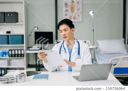 Doctor sit on table in office hospital. Attractive therapist female practitioner pharmacist smile and use tablet and laptop. after success work from treatment Doctor sit on table in office hospital. Attractive therapist female practitioner pharmacist smile and use tablet and laptop. after success work from treatment 130756064