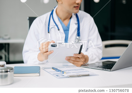 Medical technology concept. Doctor working with mobile phone and stethoscope and digital tablet laptop in modern office at hospital Medical technology concept. Doctor working with mobile phone and stethoscope and digital tablet laptop in modern office at hospital 130756078
