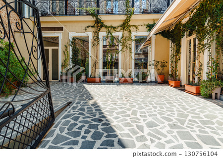 Beautiful courtyard with mosaic stone floor and potted plants in an urban setting during daytime Beautiful courtyard with mosaic stone floor and potted plants in an urban setting during daytime 130756104