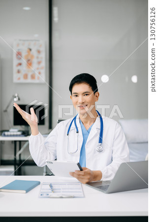 Doctor sit on table in office hospital. Attractive therapist female practitioner pharmacist smile and use tablet and laptop. after success work from treatment 130756126