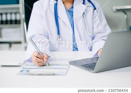 Medical technology concept. Doctor working with mobile phone and stethoscope and digital tablet laptop in modern office at hospital 130756434