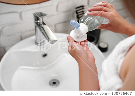 Woman preparing for her day in a modern bathroom with elegant decor and natural elements Woman preparing for her day in a modern bathroom with elegant decor and natural elements 130756467