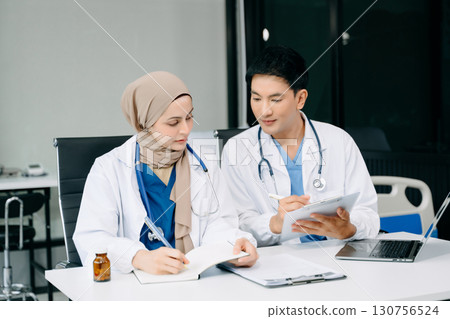 Doctors analyzing results or diagnosis of patient in clinic. Teamwork, medical and healthcare workers in discussion and research on tablet device Doctors analyzing results or diagnosis of patient in clinic. Teamwork, medical and healthcare workers in discussion and research on tablet device 130756524