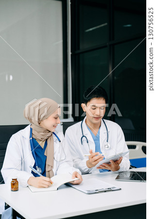 Doctors analyzing results or diagnosis of patient in clinic. Teamwork, medical and healthcare workers in discussion and research on tablet device 130756525