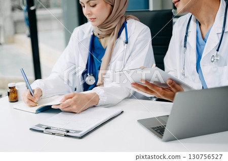 Doctors analyzing results or diagnosis of patient in clinic. Teamwork, medical and healthcare workers in discussion and research on tablet device 130756527