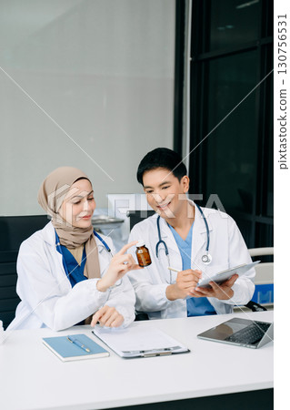 Doctors analyzing results or diagnosis of patient in clinic. Teamwork, medical and healthcare workers in discussion and research on tablet device Doctors analyzing results or diagnosis of patient in clinic. Teamwork, medical and healthcare workers in discussion and research on tablet device 130756531