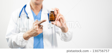 Hand in a Lab Coat and a holding a white pill bottle 130756757