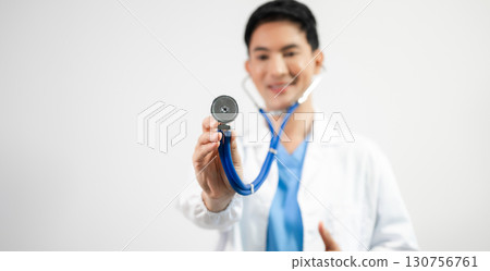 Man portrait of a doctor wearing a white coat and a stethoscope looking into the camera on a white isolated background Man portrait of a doctor wearing a white coat and a stethoscope looking into the camera on a white isolated background 130756761
