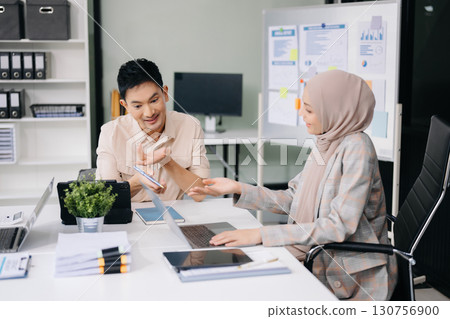 Group of professionals in an office discussing strategy, analyzing data, and collaborating on projects 130756900