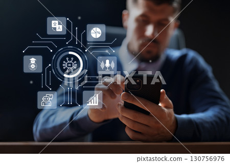 Business professional using smartphone while engaging with technology in modern office environment 130756976