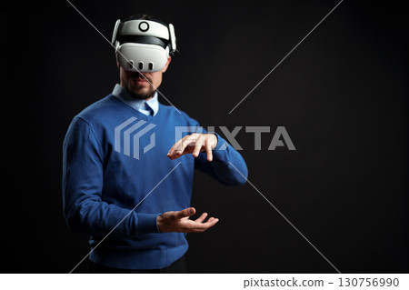 Virtual reality experience engages user in creative interaction with technology in dark studio setting 130756990