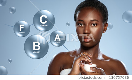 Woman applying skincare cream while surrounded by floating vitamin molecules in a bright, clean setting Woman applying skincare cream while surrounded by floating vitamin molecules in a bright, clean setting 130757086