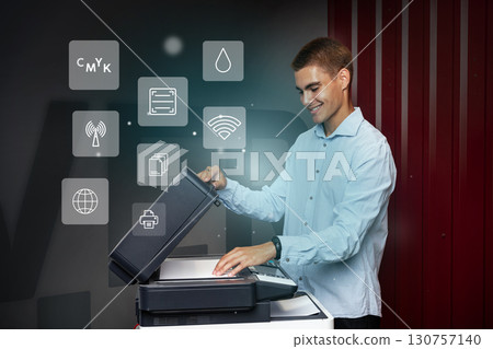 Man operates modern printer in an office setting showcasing various functions during the day 130757140