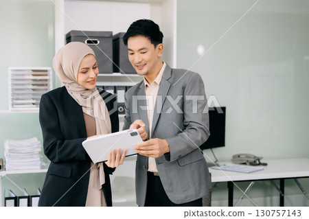 Businesswoman leading team meeting and using tablet and laptop computer with financial Businesswoman leading team meeting and using tablet and laptop computer with financial 130757143