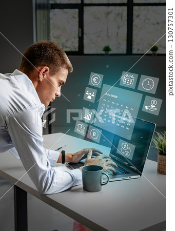Business professional using laptop in modern office with digital interface displaying productivity tools in the afternoon 130757301