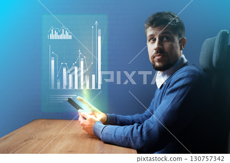 Professional man analyzing business data on a mobile device while seated at a modern desk in a well-lit office space Professional man analyzing business data on a mobile device while seated at a modern desk in a well-lit office space 130757342