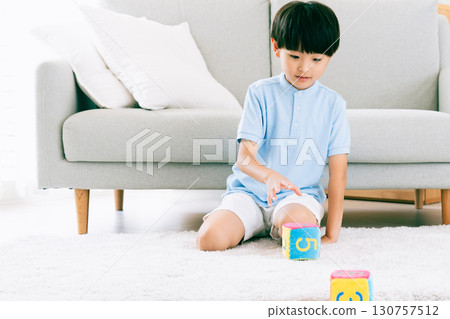 Boy playing with number dice 130757512