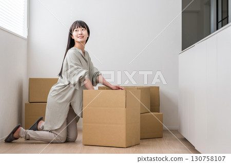 Young Asian woman tidying up cardboard boxes at home (moving, new home, new life) Young Asian woman tidying up cardboard boxes at home (moving, new home, new life) 130758107
