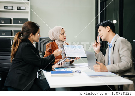 Asian businesspeople while collaborating on a new project. using a laptop and tablet Asian businesspeople while collaborating on a new project. using a laptop and tablet 130758125