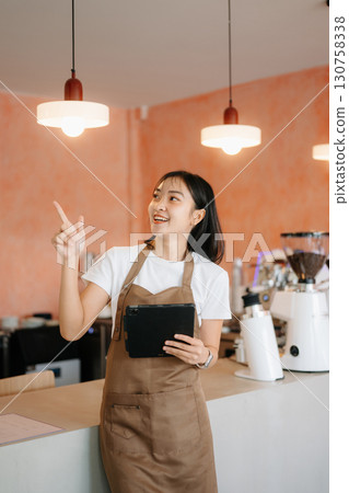 Explore professional Asian baristas brewing coffee, using notepads, digital tablets, and showcasing coffee 130758338