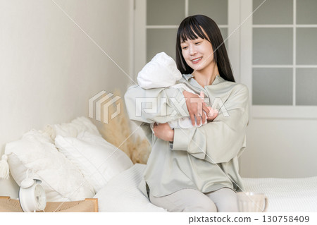 Bedroom, mother holding baby in bedroom (soothing, putting to sleep, childcare) 130758409